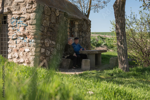 Elderly couple enjoying peaceful moment sitting at stone table