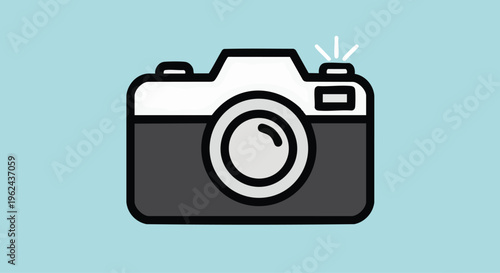 A simple, illustrated representation of a camera. The image features a stylized front-facing camera in two tones with a flash and lens