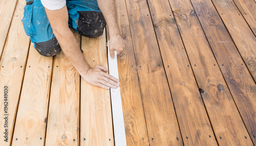 Wallpaper Mural Worker kneels on wooden deck Torontodigital.ca