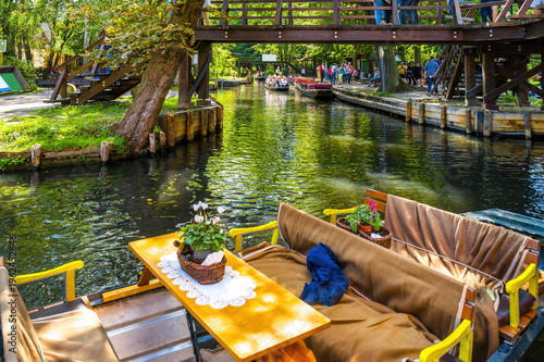 Tableau sur toile Spreewald barge with table and flowers in foreground under wooden bridge in the Spreewald