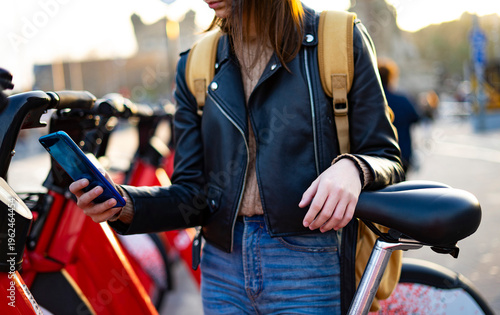 Woman renting a bicycle in the city. Electric bicycles. Rent a bike.