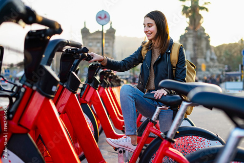 Woman renting a bicycle in the city. Electric bicycles. Rent a bike.