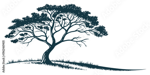 A majestic tree standing tall on a grassy hill with a clear blue sky