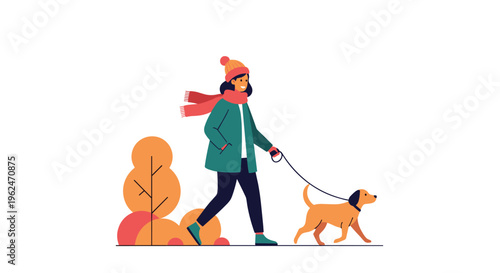 Smiling woman in warm winter clothes walking her pet dog through a park with colorful autumn trees in the background.