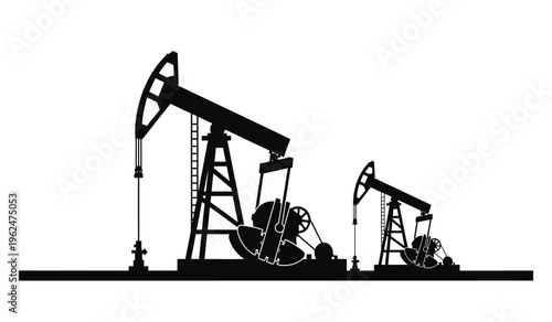 Silhouette of two oil pump jacks in operation at a drilling site