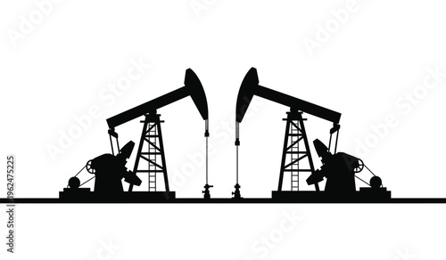 Silhouette of two oil pump jacks in operation at dusk