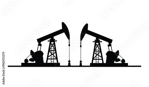 Silhouette of two oil pump jacks in operation at a drilling site