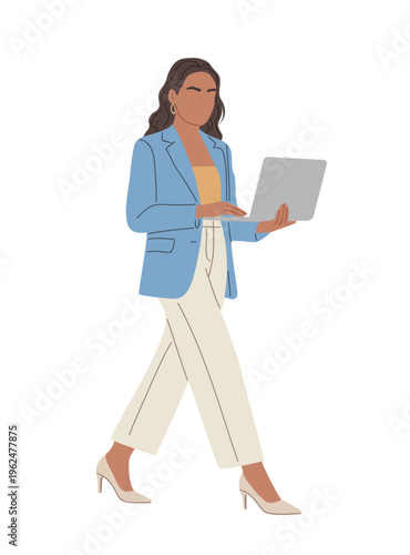 Woman walks confidently, laptop in hand. She wears a blue blazer and cream trousers. Heels complement her professional stride. Focused, she moves with purpose through her day