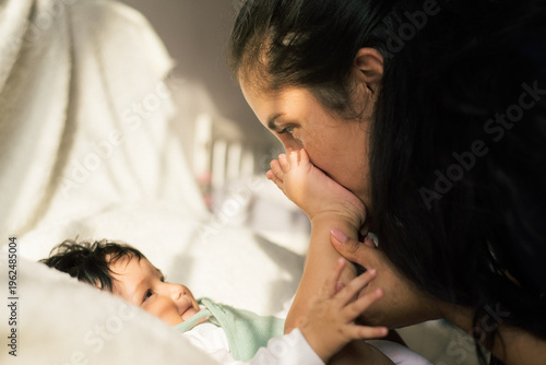 Foto Adult gently holding and kissing the baby’s foot, capturing a heartfelt and intimate bonding moment