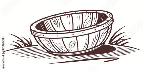 A wooden bowl resting on a grassy surface with a shadow underneath.