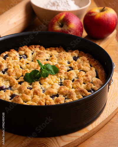 Принти на полотні Delicious homemade cherry crumble pie with fresh mint garnish on a wooden board