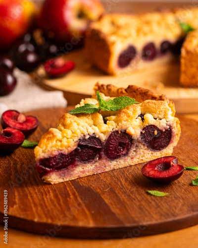 Delicious homemade cherry crumble pie with fresh mint garnish on a wooden board