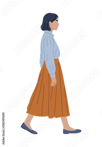 Elegant woman walks with calm confidence. Soft blue blouse meets warm-toned pleated skirt. Flat shoes complement her relaxed stride. Her dark hair frames a serene, focused expression