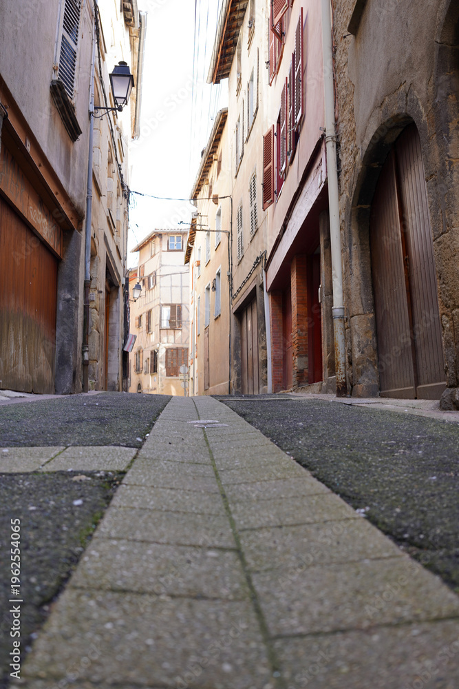 Fototapeta premium Narrow cobblestone street with old buildings in Thiers, Puy-de-Dome, France