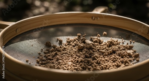 Wooden sifter with soil outdoors under sunlight