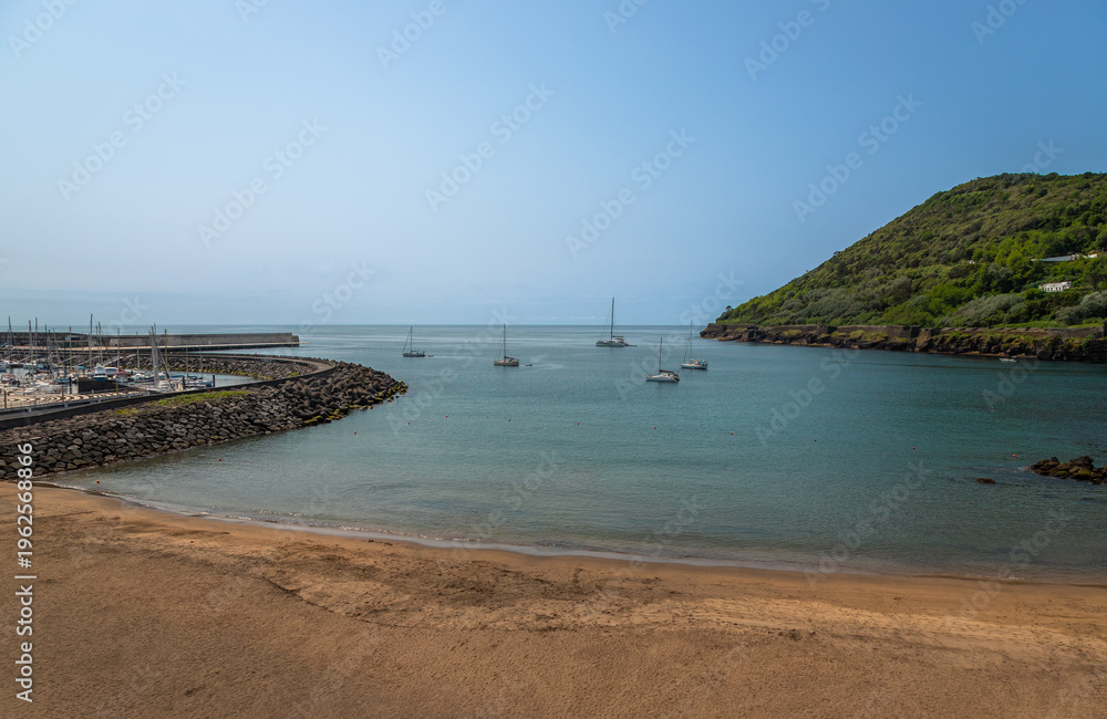 Fototapeta premium Exposure of the Prainha beach, prefect for a swim in the calm waters, located in the Terceira Island, just in the city center, near the Marina and the Fortress, Azores, Portugal
