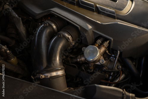 Tableau sur toile Closeup of fuel system component with hoses and connectors inside car engine bay, detailed view of mechanical parts and pipeline connections