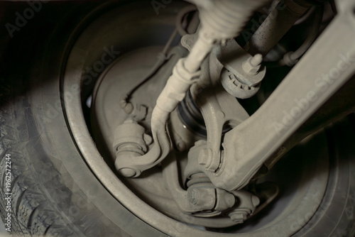 Car wheel hub and suspension components closeup, including control arms and joints inside wheel assembly, automotive mechanical system detail.