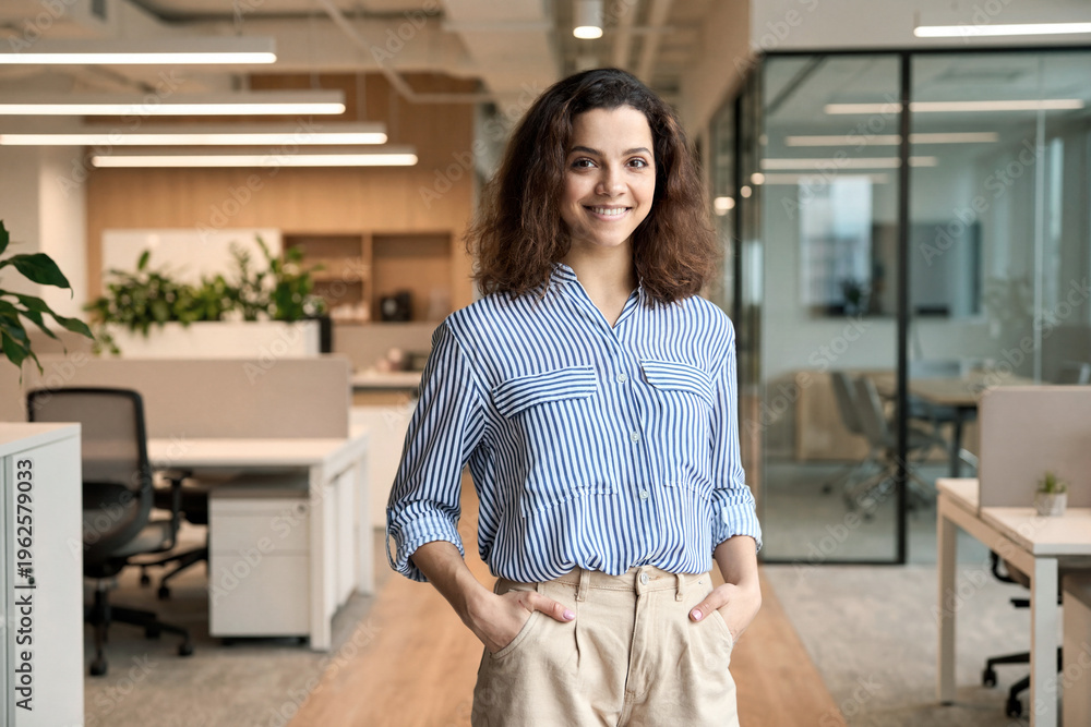 © insta_photos - Young smiling latin girl college student or teacher looking at camera standing in university campus. Happy hispanic millennial woman professional posing in modern coworking creative office space. © insta_photos - Young smiling latin girl college student or teacher looking at camera standing in university campus. Happy hispanic millennial woman professional posing in modern coworking creative office space.