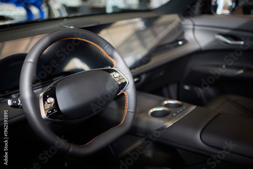 Closeup of a modern car steering wheel with control buttons for technology and convenience