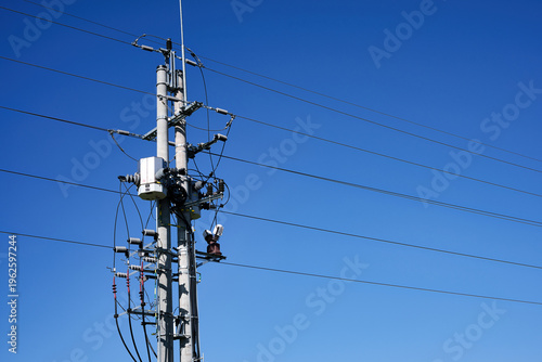 Konstfotografi Electricity power line pole and transformer against a clear blue sky background