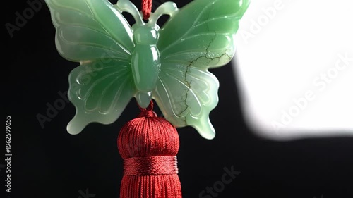 Green jade butterfly pendant with red tassel, oriental ornament, decorative element for good luck and prosperity