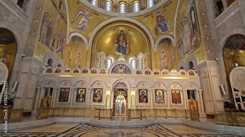 BELGRADE - SEP 19, 2025: Large church with gold trim and a gold dome. The inside is empty and the walls are covered with paintings