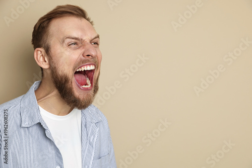 Φωτογραφία Portrait of resentful man screaming on beige background, space for text