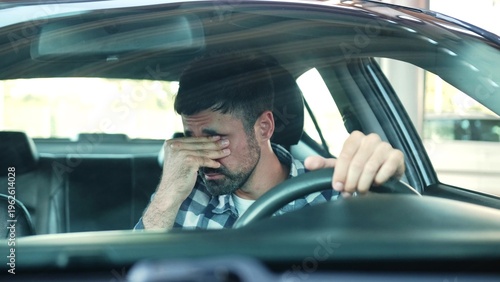 Tired man feeling stressed in a car in the city. Transport, people, lifestyle concept.