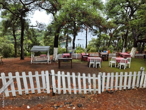 Wallpaper Mural Small outdoor restaurant with a white fence and tables. The tables are covered with red and white tablecloths Torontodigital.ca