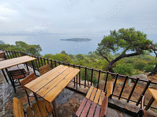 Wallpaper Mural View of a beach with a restaurant overlooking the ocean. The tables are set up with chairs and there are several dining tables with chairs around them. The restaurant has a rustic feel to it Torontodigital.ca