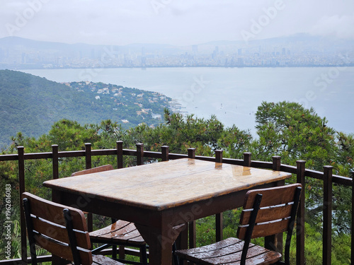 Wallpaper Mural Table with four chairs and a view of the ocean. The table is covered in rain and the chairs are wet Torontodigital.ca