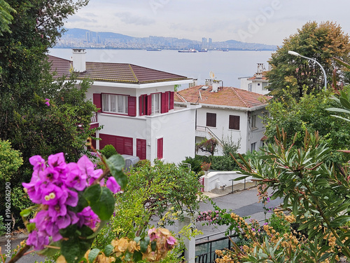 Wallpaper Mural House with a white roof and red shutters sits on a hill overlooking a body of water Torontodigital.ca