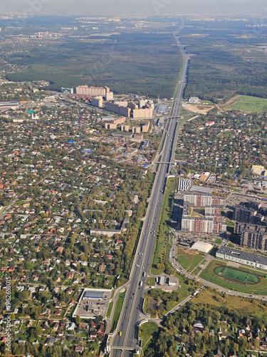 Wallpaper Mural City with a long road running through it. The road is surrounded by houses and buildings. The sky is cloudy and the city appears to be in the middle of a city Moscow Torontodigital.ca