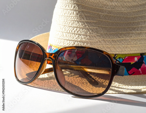Brown Sunglasses on Straw Sun Hat with Colorful Ribbon