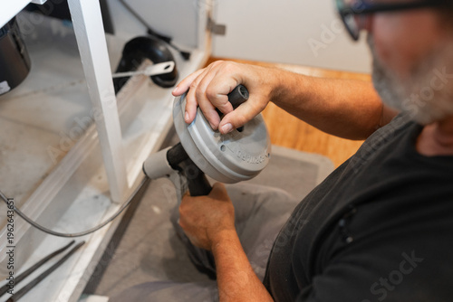 A plumber uses a drain snake, or auger, to clear a blockage from a pipe, water supply, installations, garbage disposal repair, drain cleaning