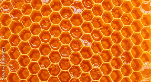 Konstfotografi Honeycomb cells filled with golden honey and bubbles close-up view