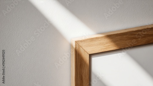 furniture. A simple wooden frame displayed on a textured white wall, highligh...