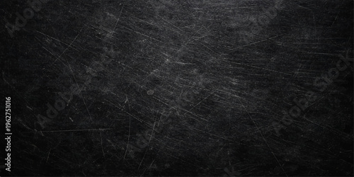 A dark grunge black paper background with a rough vintage texture and weathered grey surface creates a blank chalkboard pattern for a high-quality material backdrop