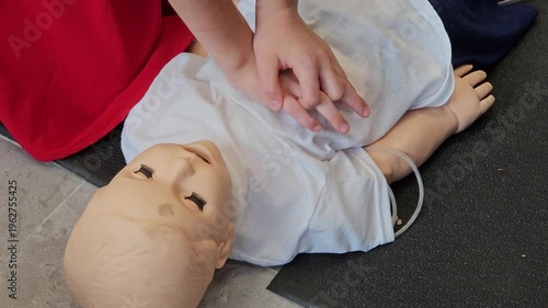 Man and child is helping CPR a doll with its chest. The doll is wearing a white shirt