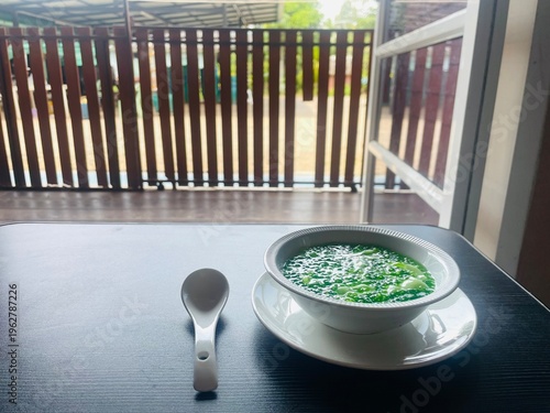 Thai dessert Sago with young coconut meat in creamy coconut milk served in a white bowl