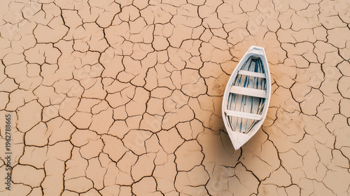 A white boat with teal accents abandoned on a dry, cracked surface, reflecting environmental degradation