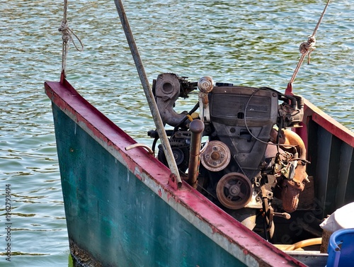 Close-up of a modified diesel engine installed on a local long-tail boat. A symbol of traditional maritime transportation in Southeast Asia, set against the rippling sea water