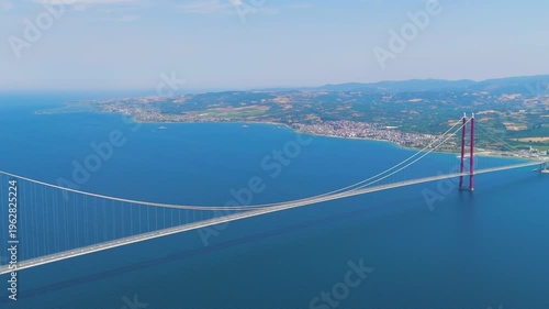 Lapseki, Turkey. Architectural panorama of 1915 Canakkale Bridge with moving cars, set against the vast blue Dardanelles. Aerial View, Departure of the camera, MasterShots