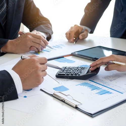 People in suits review charts and data at a meeting