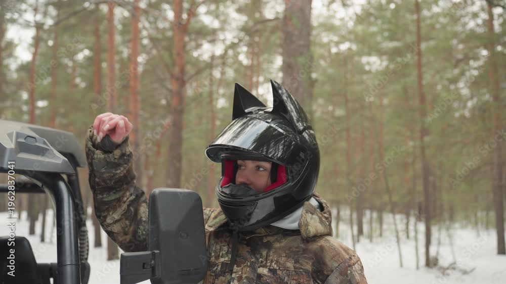 Two riders with helmets beside atv in snowy forest, driver and guide ...