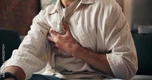 Foto Man, hands and sick in home with chest pain, heart attack symptoms or discomfort for medical problem