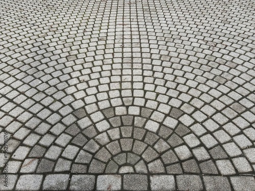 Top view on sidewalk surface. Pavement with perspective and circular pattern on cobblestones.
