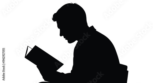 Silhouette of a man intently reading a book in stark contrast