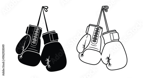 A pair of boxing gloves shown in black and white hanging by laces